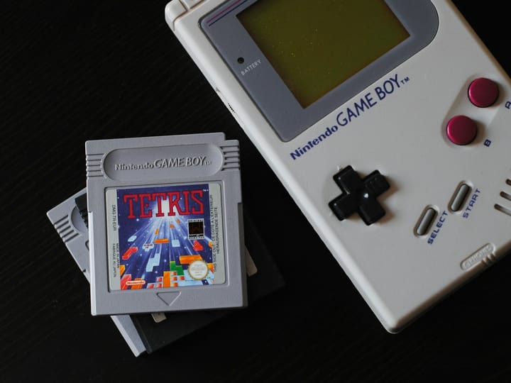 What was the first handheld console to use cartridges?